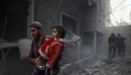 A man holds a child after an airstrike in the besieged town of Douma, Eastern Ghouta, Damascus, Syria February 7, 2018. REUTERS/Bassam Khabieh
