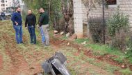 Unidentified men stand next to a piece from a missile that landed on February 10, 2018 in the eastern Lebanese town of Rayak, near the border with Syria in the Bekaa Valley. AFP / HASSAN JARRAH
