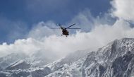 A handout picture released on February 19, 2018 by the Tasnim news agency shows members of a rescue team helicopter searching for the wreckage of Aseman Airlines flight EP3704 in Iran's Zagros mountain range. AFP PHOTO / HO / TASNIM NEWS