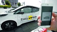 This photo taken on February 21, 2018 shows a man calling a Nissan electric vehicle Leaf equipped with an auto-driving system with exclusive software for smart phones, during a field test press preview in Yokohama, Kanagawa prefecture.  AFP / Toru Yamanak