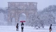 Tourists visit the Arch of Constantine during a snowfall in Rome on February 26, 2018. AFP / Vincenzo Pinto
