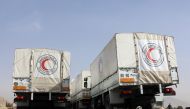 Trucks belonging to the International Committee of the Red Cross (ICRC) are seen parked on March 8, 2018, at the al-Wafideen checkpoint on the outskirts of Damascus neighbouring the rebel-held Eastern Ghouta region, as they wait for authorisation to enter