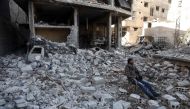 A Syrian man sits amidst the destruction in the rebel-held town of Hamouria, in the besieged Eastern Ghouta region on the outskirts of the capital Damascus, on March 9, 2018. / AFP / ABDULMONAM EASSA 