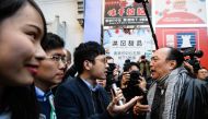 A man (R) shouts at disqualified pro-democracy lawmaker Nathan Law (C) as by-election candidate Au Nok-hin (2nd L) and disqualified pro-democracy candidate Agnes Chow (L) look on as they gather to campaign on behalf of Au for the Legislative Council by-el