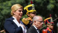 Croatian President Kolinda Grabar-Kitarovic (L) sings Croatia's national anthem next to Argentine Foreign Minister Jorge Faurie, during a wreath-laying ceremony to pay homage to Argentine national hero General Jose de San Martin, at San Martin square in B