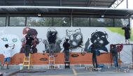  Graffiti artists spray paint a mural of panthers, in protest against the illegal wildlife poaching by construction tycoon Premchai Karnasuta, in Bangkok on March 16, 2018.  AFP / Lillian Suwanrumpha