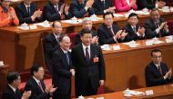 Wang Qishan (C, left), former secretary of the Central Commission for Discipline Inspection, shakes hands with China's President Xi Jinping (C) after Wang was elected as China's Vice President during the fifth plenary session of the first session of the 1