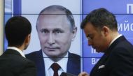 Men stand in front of a screen showing preliminary results of Russian President Vladimir Putin in the presidential election, at the headquarters of Russia's Central Election Commission in Moscow, Russia March 19, 2018. REUTERS/Sergei Karpukhin