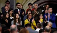Family members of jailed Catalan leaders including Meritxell Lluis (back C), wife of Josep Rull, Diana Riba (C-R), wife of Raul Romeva, and Blanca Bragulat (C), wife of Jordi Turull, along with their daughters (L) applaud at the end of a parliament sessio