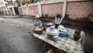 An Egyptian peddlar stands next to his boiled lupine seed cart next to a school in the capital Cairo's central Al-Malek al-Saleh district on March 25, 2018. AFP / Mohamed El-Shahed