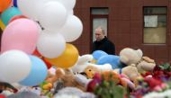 Russian President Vladimir Putin lays flowers in tribute to the victims of a fire at a shopping centre in Kemerovo on March 27, 2018.  / AFP / SPUTNIK / Alexey DRUZHININ 