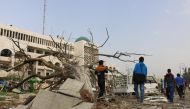 Syrians are seen near a broken down tree after a terror attack was carried out with a bomb-laden vehicle exploded, which killed 7 civilians and injured 25, in Idlib, Syria on March 24, 2018. ( Ahmed Rahhal - Anadolu

