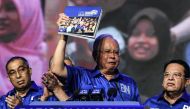 Malaysian Prime Minister Najib Razak (C) gestures as he holds a copy of his coalition's election manifesto next to other party members ahead of the upcoming polls during a National Front coalition or Barisan Nasional rally, in Kuala Lumpur on April 7, 201