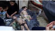 An image grab taken from a video released by the Syrian civil defence in Douma shows unidentified volunteers giving aid to children at a hospital following a reported chemical attack on the rebel-held town on April 8, 2018.  AFP Photo / Syria Civil Defenc
