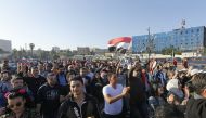 Syrians wave the national flag and wave portraits of President Bashar al-Assad as they gather at the Umayyad Square in Damascus on April 14, 2018, to condemn the strikes carried out by the United States, Britain and France against the Syrian regime. AFP /