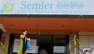 A woman talks on a mobile phone as she walks past the closed research facility of Semler Research Centre in Bengaluru, October 13, 2016. Reuters/Abhishek N Chinnappa