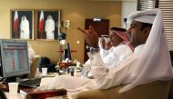 Traders monitor screens displaying stock information at Qatar Stock Exchange in Doha in this file photo of November 9, 2016. (Reuters/  Naseem Zeitoon) 