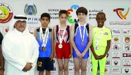 Qatar Gymnastics Federation President, Ali Al Hitmi poses for a photograph with podium winners of artistic gymnastics  competitions for primary and preparatory schools (boys)  at the prestigious 11th Schools Olympic Program 2018 (SOP) during the presentat