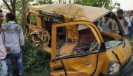 Onlookers gather around the mangled remains of a school bus after it was hit by a train in Kushinagar district in India's Uttar Pradesh state on April 26, 2018. AFP 