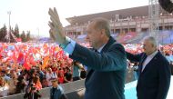 Turkish President Recep Tayyip Erdogan (L) and Turkish Prime Minister Binali Yildirim greet the crowd after attending AK Party's 6th ordinary provincial congress in western Izmir province, Turkey on April 28, 2018. AFP PHOTO / TURKISH PRESIDENTIAL PRESS S