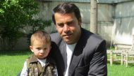 This photo taken in 2013 shows Agence France-Presse (AFP) photographer Shah Marai posing for a picture with one of his young sons, in Kabul. AFP / Ben Sheppard