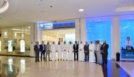 QIB Executive Management and staff members pose in front of the new branch at Tawar Mall.