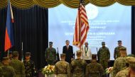 US military honour guards march with their national flag as US and Philippine officials stand at attention during the opening ceremony of the joint US and Philippines military exercise at the military headquarters in Manila on May 7, 2018.   AFP / TED ALJ