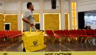 Electoral worker carries ballot boxes at the collation centre after the general election, in Petaling Jaya, Malaysia, May 9, 2018. REUTERS/Lai Seng Sin

