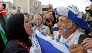 An Israeli man confronts a Palestinian woman at Damascus gate in Jerusalem on May 13, 2018, as Israeli nationalist settlers celebrate the Jerusalem Day in the Old City.  AFP / Menahem Kahana