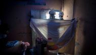 Bismark Owusu, a worker of Anglogold Ashanti Malaria Ltd covers furnitures before to spray the walls of a house with insecticide against mosquitos on May 2, 2018 in Adansi Domeabra, near Obuasi, Ashanti Region. AFP / CRISTINA ALDEHUELA