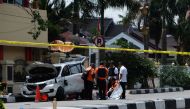 Indonesian policemen examine a car used by attackers outside the police headquarter in Pekanbaru, Riau following attacks on May 16, 2018. AFP / DEDY SUTISNA