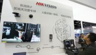 Visitors are seen at a booth of security camera supplier Hikvision Digital Technology during an expo at the National Convention Center in Beijing, China March 12, 2018. Reuters/Stringer