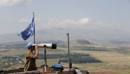 A United Nations Truce Supervision Organisation military observer uses binoculars near the border with Syria in the Israeli-occupied Golan Heights, Israel May 11, 2018. Reuters/Baz Ratner