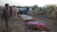Indian police stand near the bodies of some of the victims of an accident on the Ahmedabad-Bhavnagar highway in Bavniyari village on May 19, 2018.   AFP / STR
