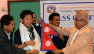 In this file photo taken on August 23, 2015 Japanese climber Nobukazu Kuriki (2nd L) accepts a permit to climb Mount Everest and a Nepalese flag from Nepal's tourism minister Kripasur Sherpa (R) in Kathmandu.  / AFP / Prakash MATHEMA 