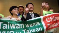 Taiwan's Health Minister Chen Shih-Chung (C) gives a thumb up as he poses with demonstrators after a press conference on the sideline of the World Health Assembly on May 21, 2018 in Geneva. AFP / Fabrice Coffrini 