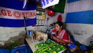 This photograph taken on May 17, 2018 shows a Bangladeshi worker sewing flag for world cup football playing nations in Narayanganj, on the outskirts of Dhaka, ahead of the 2018 football World Cup. AFP / Munir UZ ZAMAN 