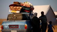Displaced Syrians from the Daraa province fleeing shelling by pro-government forces wait in a makeshift camp to cross the Jordanian border, near the town of Nasib, southern Syria, on July 1, 2018.  AFP / Mohamad ABAZEED
