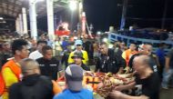 Thai rescue and paramedic personnel attend to rescued passengers of capsized tourist boat in rough seas at a port in Phuket on July 5, 2018. AFP / Kritsada Muenhawong