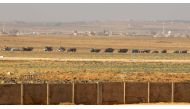 A convoy of Syrian military vehicles can be seen from the Jordanian Marfaq governate at the Nassib border between the two countries on June 7, 2018. AFP / STR