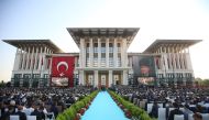 This hand out picture taken and released on July 9, 2018 by Turkish President Office shows people listening Turkish President Recep Tayyip Erdogan (unseen) delivering a speech at the Presidential Complex in Ankara. AFP / Turkish President Office / Kayhan 