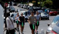 People use Electric scooters of the US company Lime in Paris on July 9, 2018. AFP / Francois Guillot

