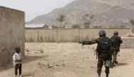 FILE PHOTO: Cameroonian soldiers from the Rapid Intervention Brigade tell a young boy to stay back while on patrol in Kerawa, Cameroon, March 16, 2016. Joe Penney/Reuters 