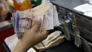 A cashier counts Venezuelan bolivar notes in a state-run supermarket in Caracas, January 9, 2015. Reuters/Carlos Garcia Rawlins