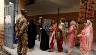 A soldier keeps watch as voters line up to enter at a polling station during general election in Rawalpindi, Pakistan July 25, 2018. REUTERS/Faisal Mahmood