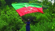 A supporter of cricket star-turned-politician Imran Khan, chairman of Pakistan Tehreek-e-Insaf (PTI), waves a party flag as he celebrates outside his residence in Islamabad, Pakistan, a day after polling in the general election, July 26, 2018. Reuters/Fai