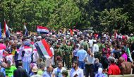 Syrians wave the national flag in the town of Quneitra in the Syrian Golan Heights on July 27, 2018. The town was almost completely destroyed by departing Israeli soldiers in 1974 after seven years of occupation. AFP / Youssef Karwashan