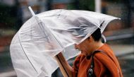 A passerby using an umbrella struggles against a heavy rain and wind as Typhoon Jongdari approaches Japan's mainland in Tokyo, Japan July 28, 2018. Reuters/Issei Kato