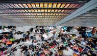 Travellers gather in front of information boards at the Terminal 2 at Munich airport on July 28, 2018 as around 200 flights had to be cancelled and two terminals evacuated after an unidentified person entered a secure area. AFP / dpa / Matthias Balk