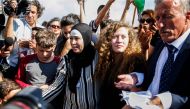 Palestinian activist and campaigner Ahed Tamimi (C) stands alongside her father (R), mother (C-L), and brother (L) upon her release from prison after an eight-month sentence for slapping two Israeli soldiers, in the West Bank village of Nabi Saleh on July